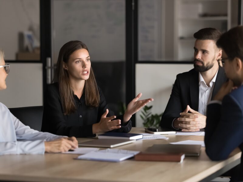 Serious,Young,And,Mature,Colleagues,Brainstorm,At,Conference,Table,,Listening